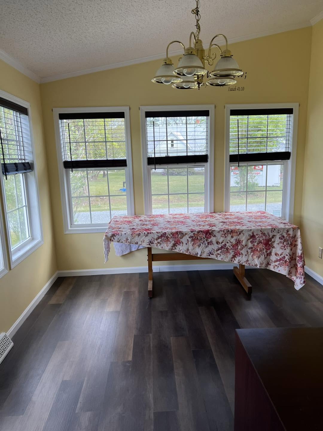 Bright sunroom dining area with new plank flooring
