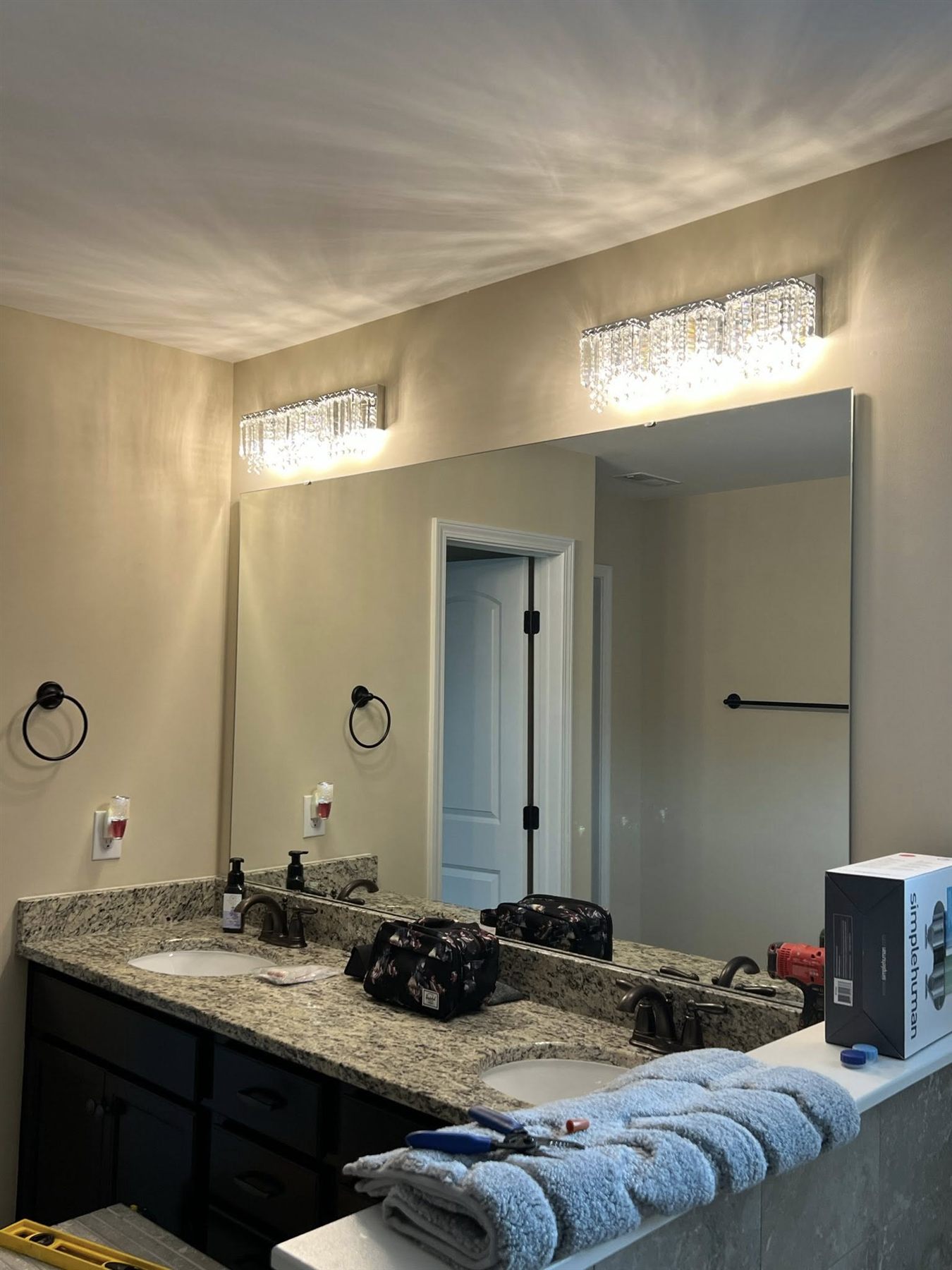 Primary bathroom with granite double vanity and crystal light bars